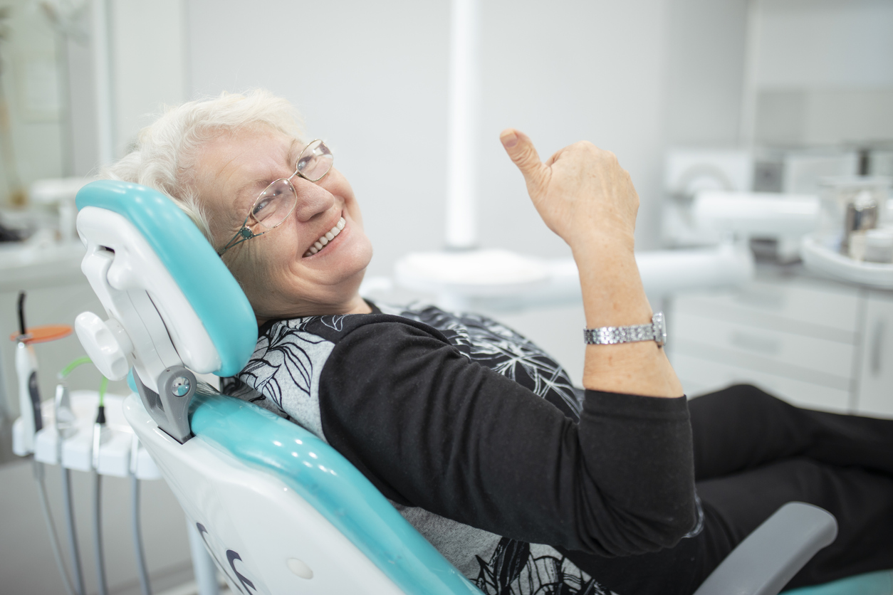 Old senior woman sitting in a dental chair Old senior woman sitting in a dental chair thumb up